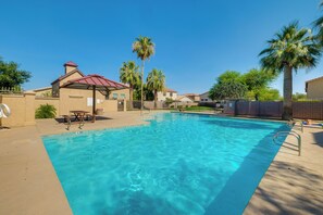 A clear blue pool surrounded by a fenced area with palm trees and a building with a red roof. - Relax Poolside! Retreat 2 Mi to Santan Mtn Casino (Chandler)