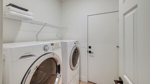 A laundry area with two front-loading washing machines, a drying rack with folded towels, and a closed door. - Relax Poolside! Retreat 2 Mi to Santan Mtn Casino (Chandler)