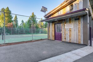 A wooden building with a sign reading 'The CLUBHOUSE' and a fenced tennis court in the background. - Private Deck & Hot Tub! Family Sanctuary in Frisco (Frisco)