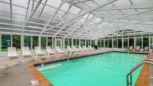 A covered swimming pool with lounge chairs and an exit sign. - Mtn Views, Pool Access! Walkable Gem Near Parkway (Pigeon Forge)