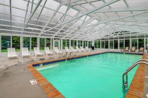 A covered swimming pool with lounge chairs and an exit sign. - Mtn Views, Pool Access! Walkable Gem Near Parkway (Pigeon Forge)