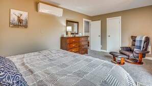 A bedroom with a large bed, a dresser, a chair, and a painting on the wall. - Hiking Days, Fireside Nights! Colorado Springs Gem (Colorado Springs)