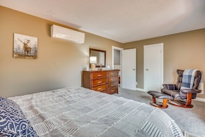 A bedroom with a large bed, a dresser, a chair, and a painting on the wall. - Hiking Days, Fireside Nights! Colorado Springs Gem (Colorado Springs)