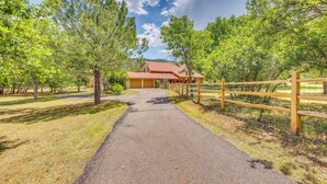 A paved pathway leading to a building with a red roof, surrounded by trees and a wooden fence. - Hiking Days, Fireside Nights! Colorado Springs Gem (Colorado Springs)