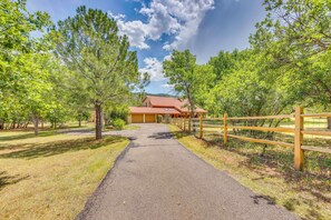 A paved pathway leading to a building with a red roof, surrounded by trees and a wooden fence. - Hiking Days, Fireside Nights! Colorado Springs Gem (Colorado Springs)