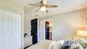 A bedroom with a bed, a ceiling fan, a dresser, a closet, and a door leading to another room. - Modern Lakeland Retreat w/ Office I Fenced Yard (Lakeland)