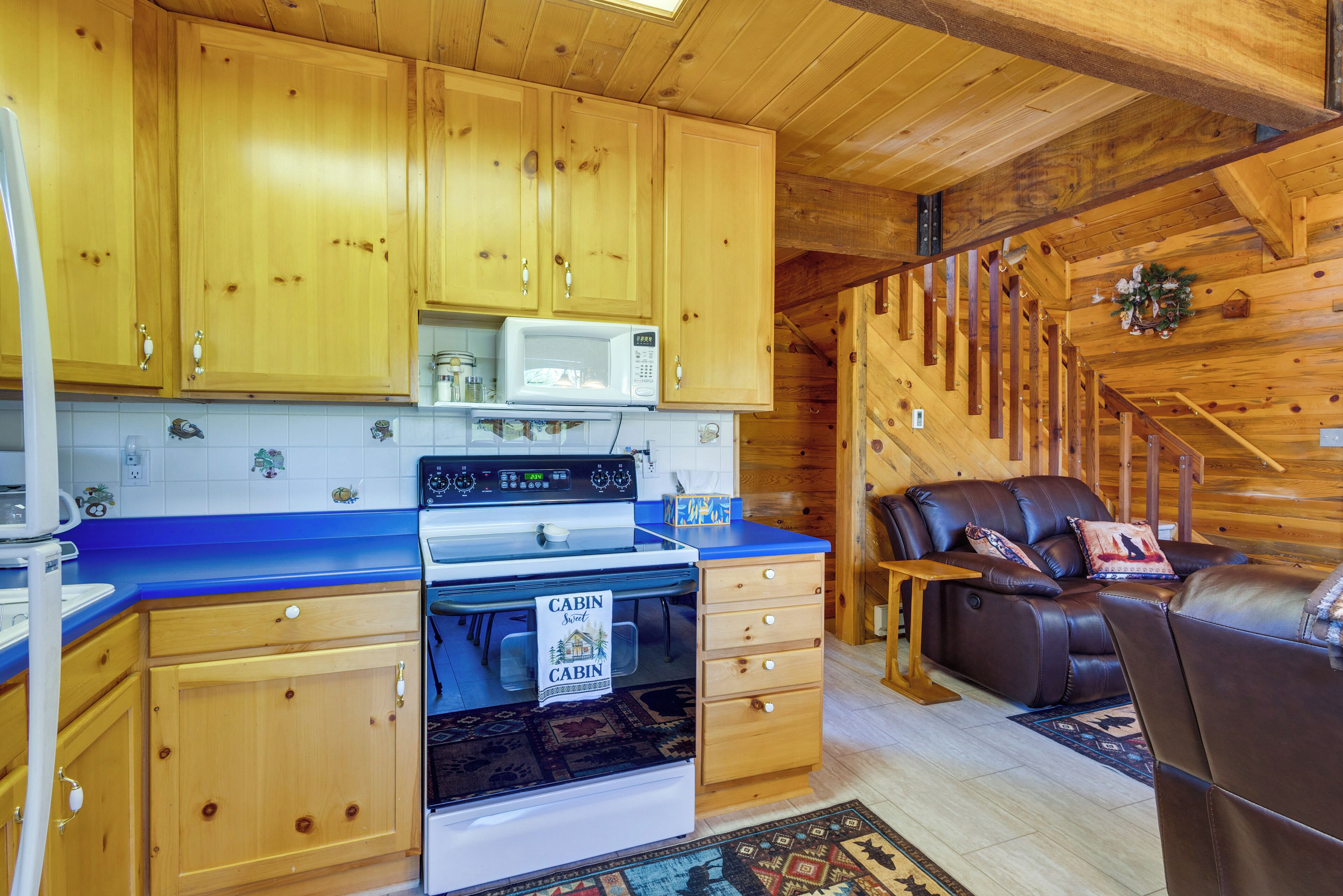 L’intérieur d’une cabine est aménagé avec des meubles en bois, un four à micro-ondes, une cuisinière, un canapé et un escalier.