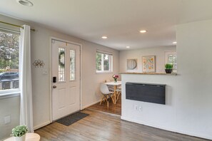A modern kitchen with a dining area, wooden flooring, and a white door with glass panels. - 1 Mi to Olde Town Arvada! Updated Home w/ Patio (Arvada)
