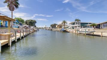 A canal with boats docked, wooden walkways, and buildings with balconies along the water's edge.