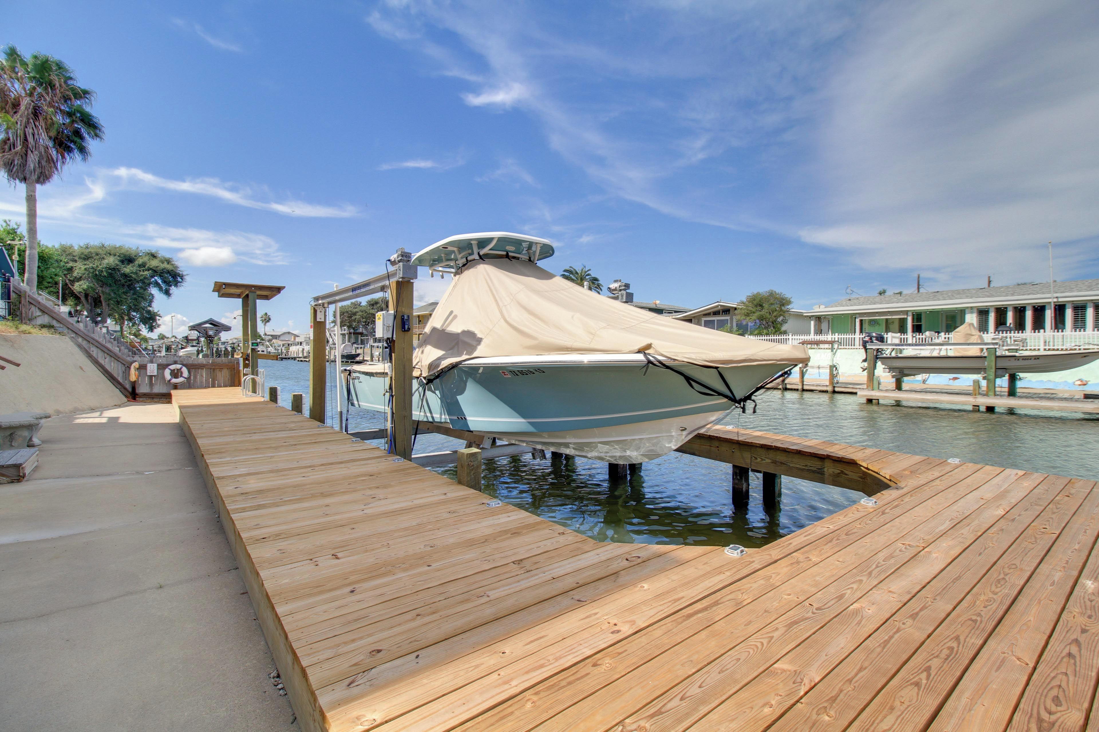 A boat docked at a wooden pier with a clear sky above.