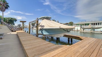 A boat docked at a wooden pier with a clear sky above.