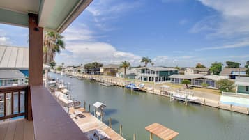 A waterfront property with a dock, boats, and houses along the water.