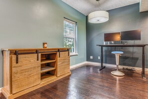 A room with a wooden cabinet, a table with a computer, and a window. - Treehouse Views! Walking Distance to IMS (Indianapolis)