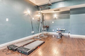 A room with a treadmill, exercise equipment, and a projector on the ceiling. - Treehouse Views! Walking Distance to IMS (Indianapolis)