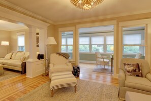 A spacious living room with a sofa, armchair, ottoman, and a chandelier. - 'the Hand House!' Walk to Downtown & Race Course (Saratoga Springs)