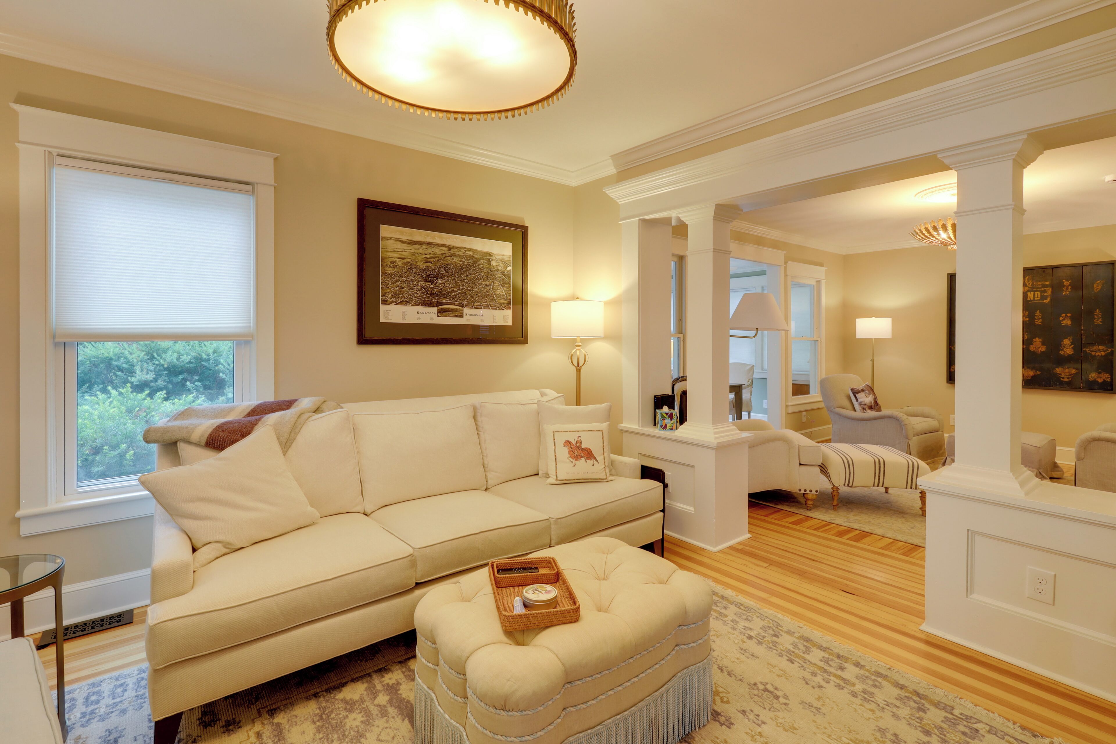 A living room with a beige sofa, a coffee table, and a framed map on the wall.