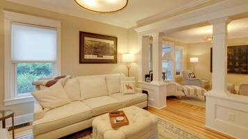 A living room with a beige sofa, a coffee table, and a framed map on the wall.