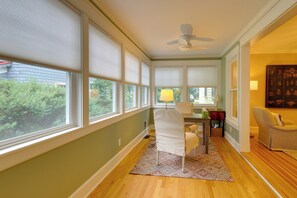 A room with large windows, a ceiling fan, a dining table with chairs, and a side table with a lamp. - 'the Hand House!' Walk to Downtown & Race Course (Saratoga Springs)