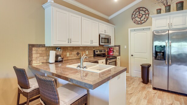 A kitchen with white cabinets, a stainless steel refrigerator, a microwave, and a coffee maker. - Lakefront Gem w/ Boat Dock! 6 Mi to Hot Springs NP (Hot Springs)