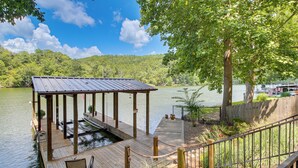 A wooden dock with a covered seating area, a small pond, and a view of a lake and forested hills. - Lakefront Gem w/ Boat Dock! 6 Mi to Hot Springs NP (Hot Springs)