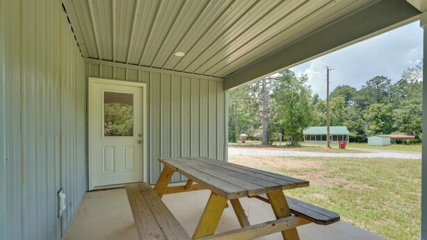 A covered outdoor area with a picnic table and a door leading to a building. - < 1 Mi to Broad River Campground! Rural Retreat (Tignall)