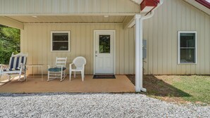 A building with a covered porch, a door, and two windows. - Hunt & Fish! Home < 1 Mi to Broad River Campground (Tignall)