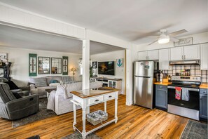 A modern kitchen with a stainless steel refrigerator, a built-in oven, and a wooden countertop.