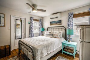 A bedroom with a bed, a nightstand, a ceiling fan, an air conditioning unit, and a window with curtains. - Block and Half to Beach! Minutes From AC, Casinos (Brigantine)