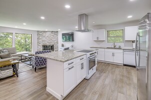 A modern kitchen with white cabinetry, a granite countertop, and a built-in oven.