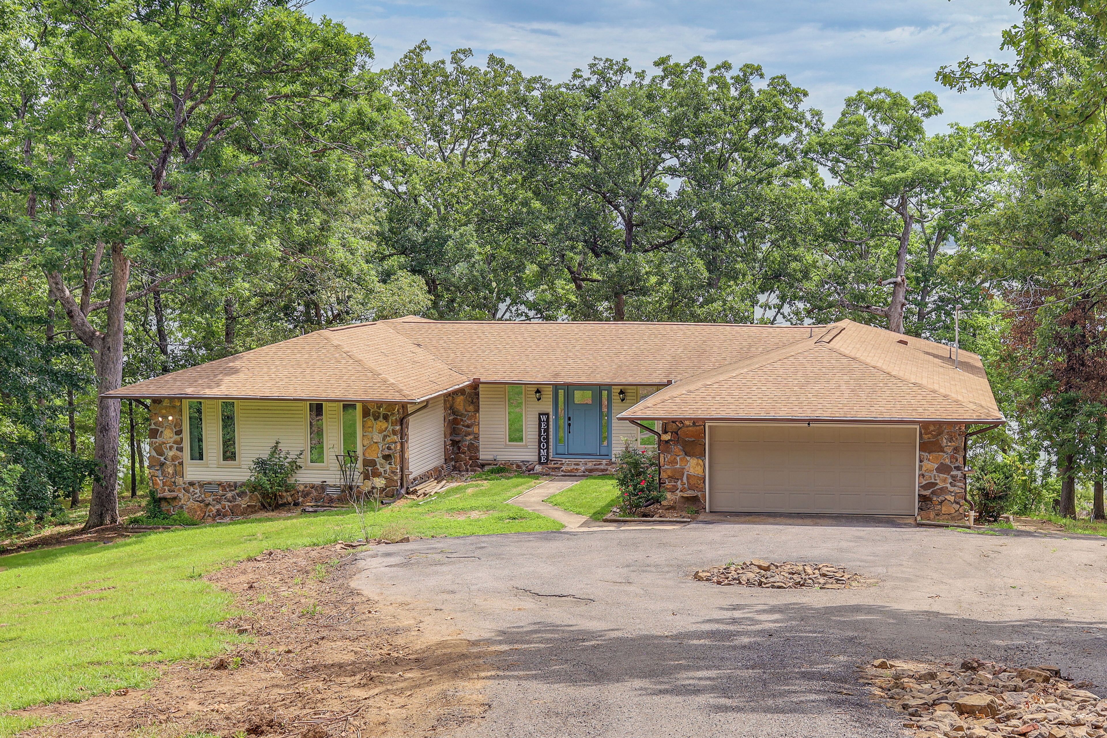 A two-story house with a stone exterior, a front porch, and a garage.