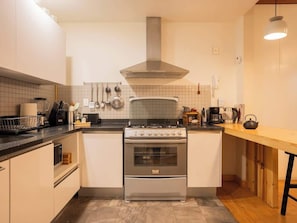 A kitchen with a stove, oven, and various utensils. - Bright Escandón 2BR | Private Patio Near Condesa (Mexico City)