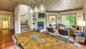 A spacious living area with a wooden ceiling, a dining table with chairs, and a cozy seating area with a sofa and a lamp. - Spacious Home w/ Hot Tub & Views in Black Mountain (Black Mountain)
