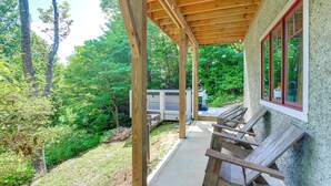 A covered outdoor area with a wooden deck, a concrete pathway, and a view of a natural forested area. - Spacious Home w/ Hot Tub & Views in Black Mountain (Black Mountain)