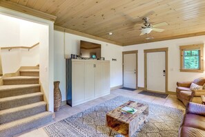 Un vaste espace de vie comprenant un escalier, une grande armoire, une table basse et un canapé en cuir.
