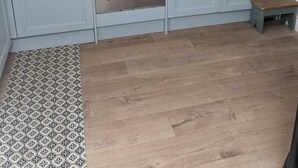 Eine Küche mit Gaskochfeld, Backofen und einem kleinen Holzschemel.