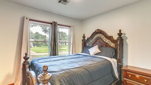 A bedroom with a large bed, a wooden dresser, and a window with curtains. - 4 Mi to Sabine River! Extended Escape w/ Yard (Orange)
