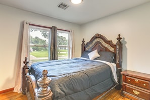 Un dormitorio con una cama grande, un aparador de madera y una ventana con cortinas.