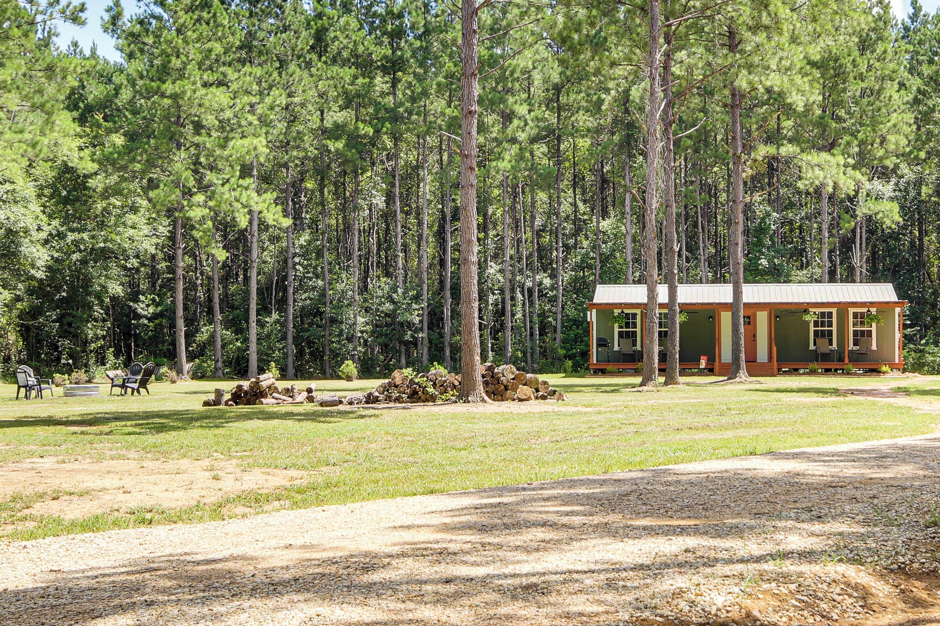 A lodge with a simple, rustic design, surrounded by a dense forest.