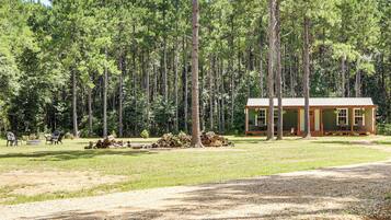 A lodge with a simple, rustic design, surrounded by a dense forest.