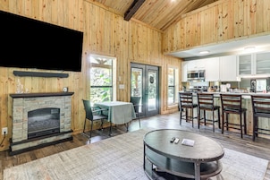 Un interior de madera con chimenea, comedor y cocina.