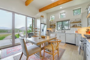 Una cocina moderna con una isla grande, armarios blancos y vistas al exterior.
