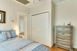 Un dormitorio con cama, cómoda, espejo y puerta.