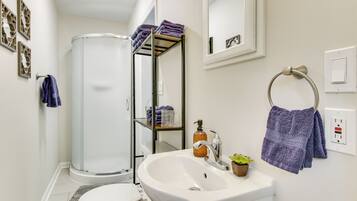 A modern bathroom with a toilet, sink, and shower.