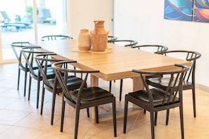 A dining area with a wooden table and black chairs, a vase, and a painting on the wall. - Mesa Retreat Heated Pool Game Room Great For Families (Mesa)