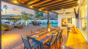 Eine Außenpatio mit Pool, Essbereich und Liegestühlen.