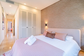 Ein Hotelzimmer mit Bett, Kleiderschrank, Wandlampe und Flur.
