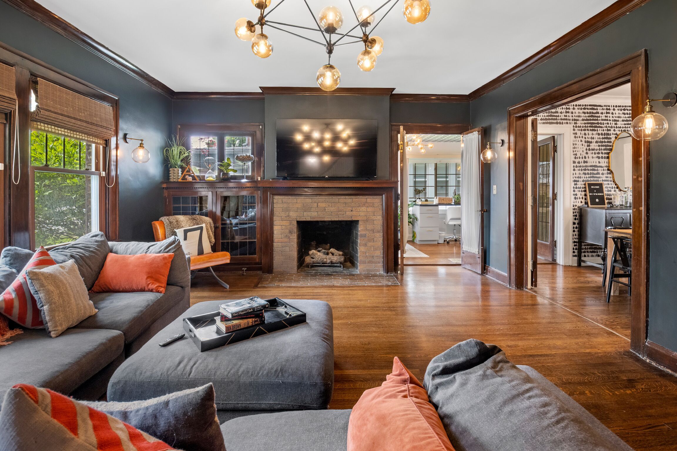 A living room with a fireplace, a sofa set, a television, and a dining area.