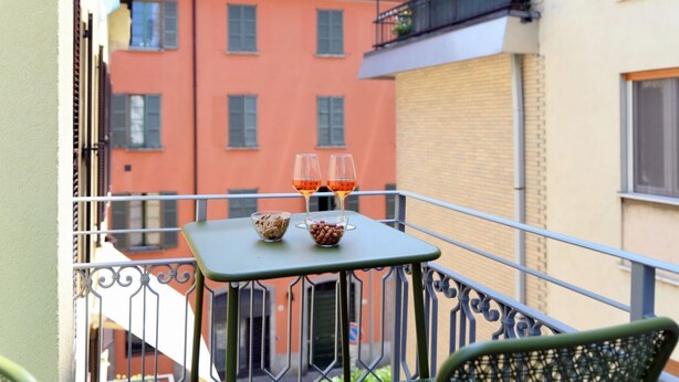 Un balcon avec une table, deux verres et des bols remplis de collations.
