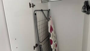 Een kamer met een metalen hek, een handdoekhouder en een gordijn met een patroon.