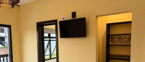 Une chambre à coucher avec un lit, une télévision et un plancher en bois.